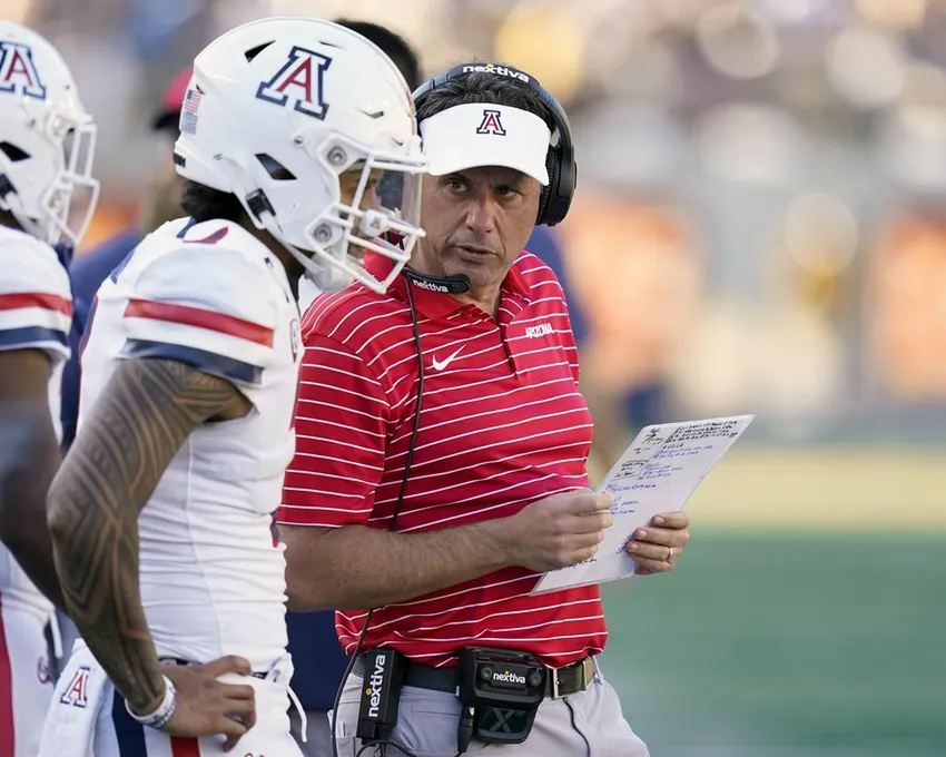 L'entraîneur principal de l'Arizona, Jedd Fisch, à droite, discute avec le quarterback Jayden de Laura, deuxième à partir de la gauche, avant que l'attaque n'entre sur le terrain contre la Californie pendant la deuxième mi-temps d'un match de football universitaire NCAA à Berkeley, en Californie, Samedi 24 septembre 2022.