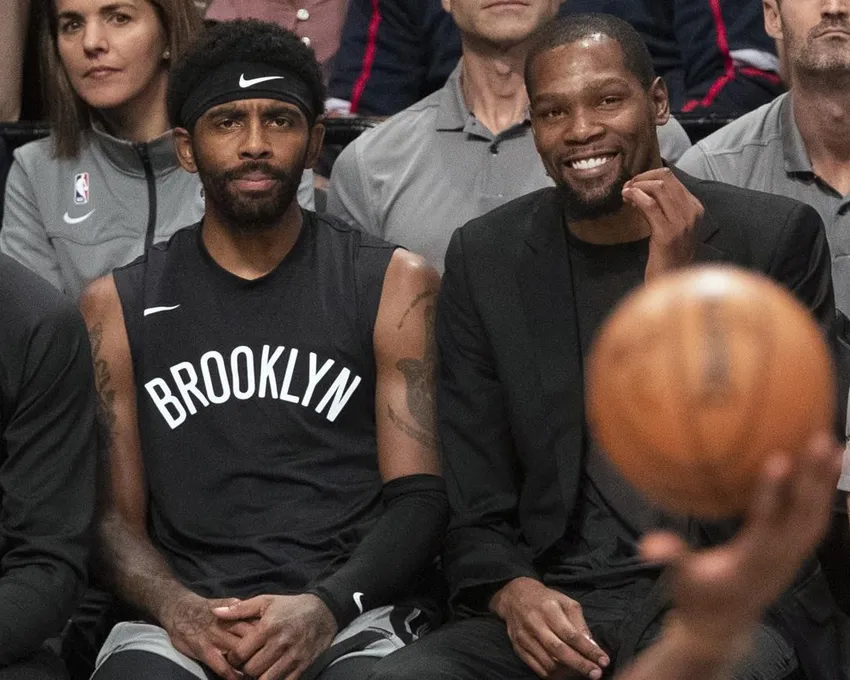 Sur cette photo d'archive du 1er novembre 2019, Kyrie Irving, à gauche, et Kevin Durant, des Brooklyn Nets, regardent l'action du match depuis le banc pendant la deuxième mi-temps d'un match de basket-ball de la NBA contre les Houston Rockets à New York. Kevin Durant a demandé à partir, mais il pensait qu'il ne le ferait pas. Kyrie Irving voulait rester, mais craignait de partir. Alors que l'intersaison chaotique des Brooklyn Nets se déroulait, même les joueurs clés avaient du mal à donner un sens aux choses qui se passaient. Maintenant, les Nets sont prêts à laisser tout cela derrière eux pour entamer une nouvelle saison.