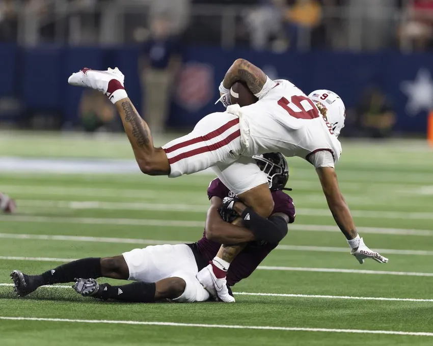 Le défenseur du Texas A&M Tyreek Chappell tacle le receveur large de l'Arkansas Jadon Haselwood (9) pendant la seconde moitié d'un match de football universitaire de la NCAA, samedi 24 septembre 2022, à Arlington, au Texas. Le Texas A&M a gagné 23-21.