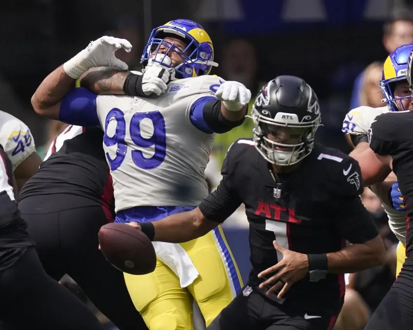 Le plaqueur défensif des Los Angeles Rams, Aaron Donald (99), est tenu à l'écart du quarterback des Atlanta Falcons, Marcus Mariota (1), par le plaqueur offensif des Atlanta Falcons, Elijah Wilkinson, pendant la première mi-temps d'un match de football NFL, dimanche 18 septembre 2022, à Inglewood, en Californie.