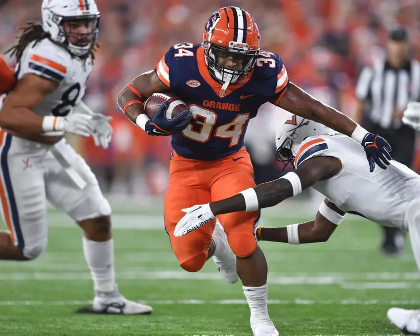 Le running back de Syracuse, Sean Tucker (34), tente de se défaire d'un plaquage du cornerback de Virginia, Anthony Johnson, pendant la première mi-temps d'un match de football universitaire NCAA, vendredi 23 septembre 2022, à Syracuse. 23, 2022, à Syracuse, N.Y.