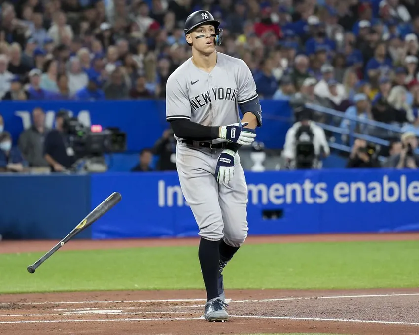 Aaron Judge (99), voltigeur de droite des New York Yankees, lance sa batte alors qu'il se fait marcher dessus par le lanceur partant des Blue Jays de Toronto, Kevin Gausman (34), lors de la troisième manche de la Ligue américaine de baseball MLB, à Toronto, le lundi 26 septembre 2022.