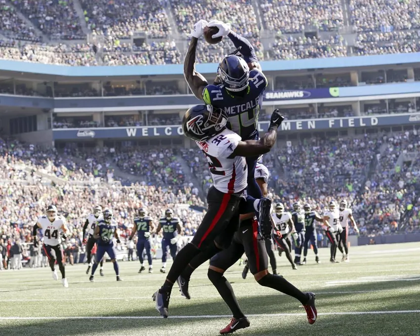 Le receveur large des Seattle Seahawks, DK Metcalf, fait une prise dans la zone d'en-but pour un touchdown alors que la sécurité des Atlanta Falcons Jaylinn Hawkins défend pendant la première mi-temps d'un match de football NFL, dimanche 25 septembre 2022, à Seattle.