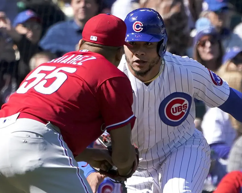 Le lanceur partant Ranger Suarez (55) des Phillies de Philadelphie tente de toucher Willson Contreras des Cubs de Chicago sur la ligne de troisième base, mais Contreras a été retiré par l'arbitre du marbre Ted Barrett après avoir quitté la trajectoire de la base pendant la première manche d'un match de baseball jeudi 29 septembre 2022 à Chicago. 29, 2022, à Chicago.