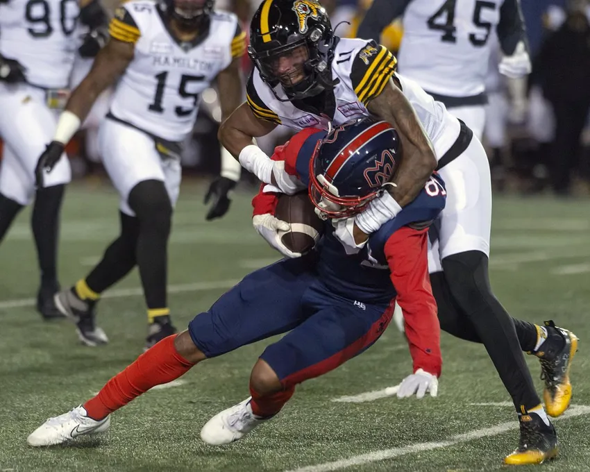 Kameron Kelly des Tiger-Cats de Hamilton tacle Tyson Philpot des Alouettes de Montréal pendant la première mi-temps d'une action de football de la LCF à Montréal, le vendredi 23 septembre 2022.