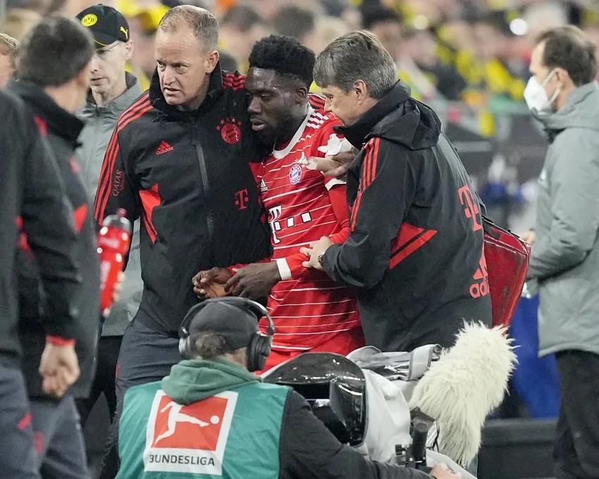 Alphonso Davies du Bayern, au centre, quitte le terrain après s'être blessé lors du match de football de Bundesliga allemande entre le Borussia Dortmund et le Bayern Munich à Dortmund, en Allemagne, samedi 8 octobre 2022.