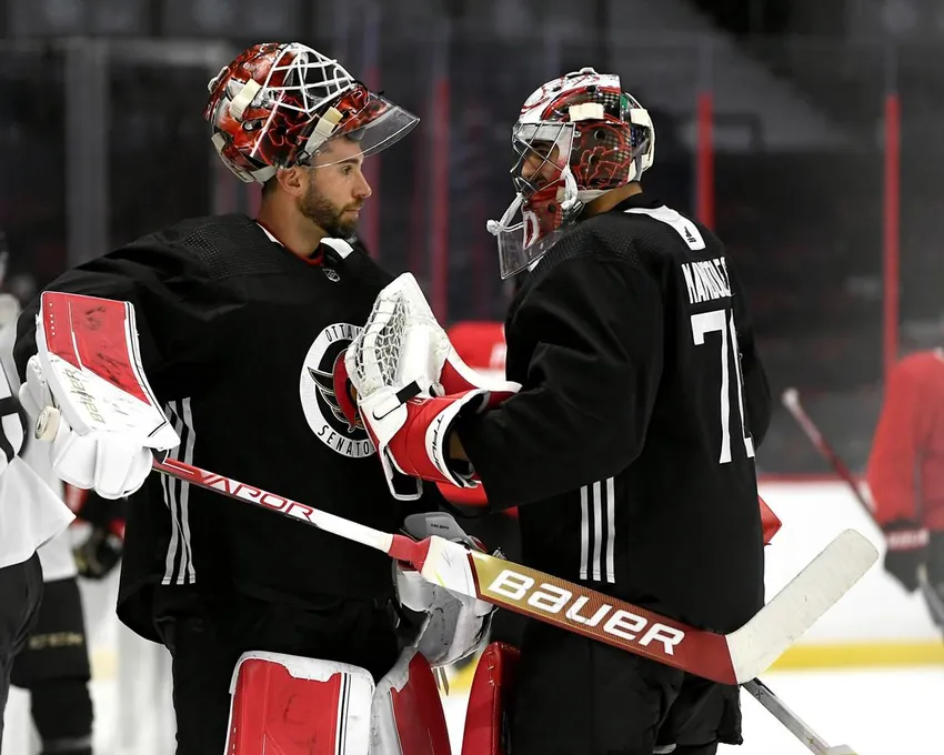 Le gardien de but des Sénateurs d'Ottawa Cam Talbot (33) frappe le gardien Kevin Mandolese (70) avec son bâton alors qu'ils se saluent au camp d'entraînement de l'équipe à Ottawa, le 22 septembre 2022.