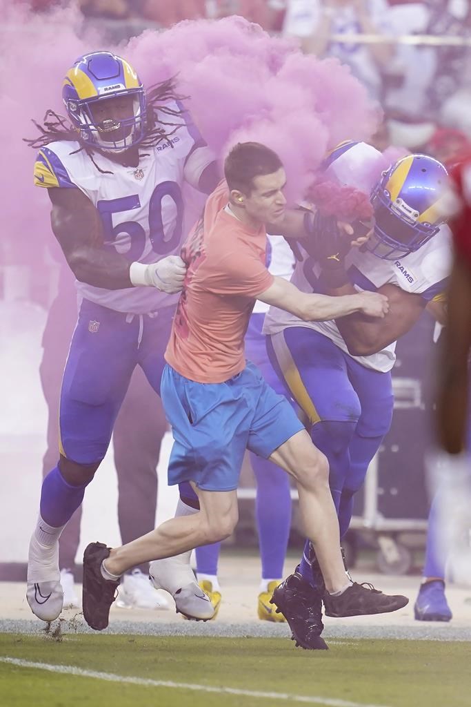 Le LB Bobby Wagner des Rams aplatit un manifestant qui entre sur le terrain