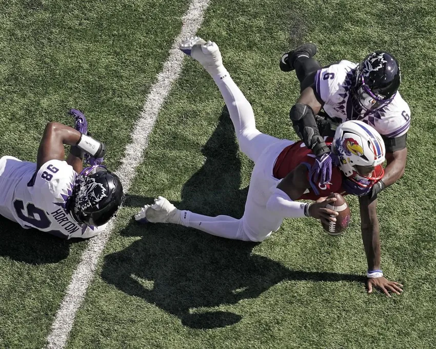 Le quart-arrière du Kansas, Jalon Daniels, est plaqué par le secondeur de TCU, Jamoi Hodge (6), pendant la première mi-temps d'un match de football universitaire de la NCAA, samedi 8 octobre 2022, à Lawrence, au Kan.