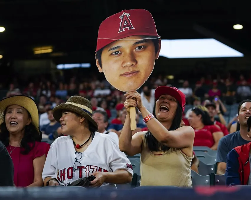 Un fan brandit une découpe de la tête du frappeur désigné des Los Angeles Angels, Shohei Ohtani (17), pendant un match de baseball contre les Oakland Athletics à Anaheim, en Californie, Mardi 27 septembre 2022.