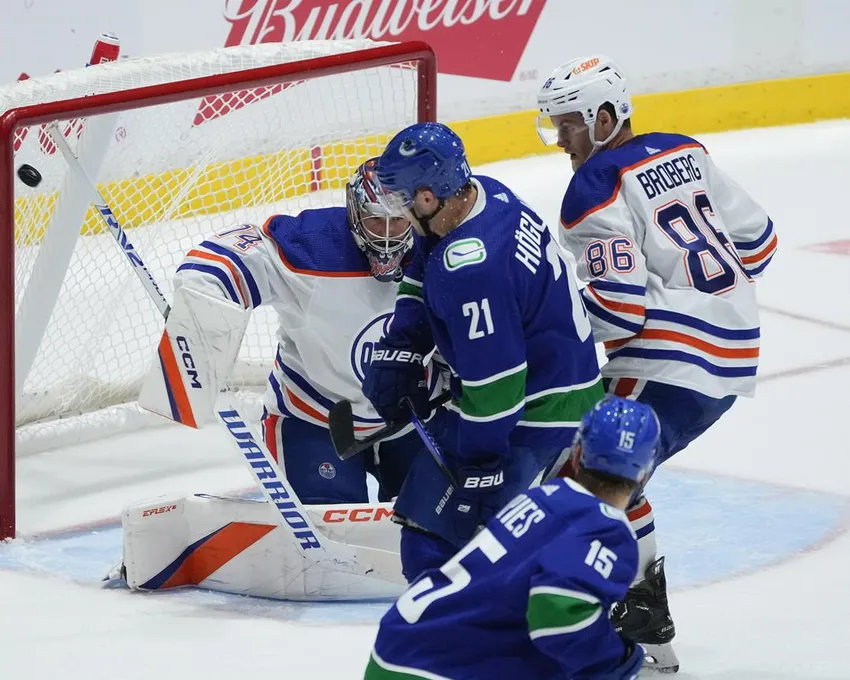 Le Suédois Nils Hoglander (21) des Canucks de Vancouver marque contre le gardien Stuart Skinner (74) des Oilers d'Edmonton au cours de la première période d'un match de hockey présaison de la LNH à Abbotsford, en Colombie-Britannique, le mercredi 5 octobre 2022.