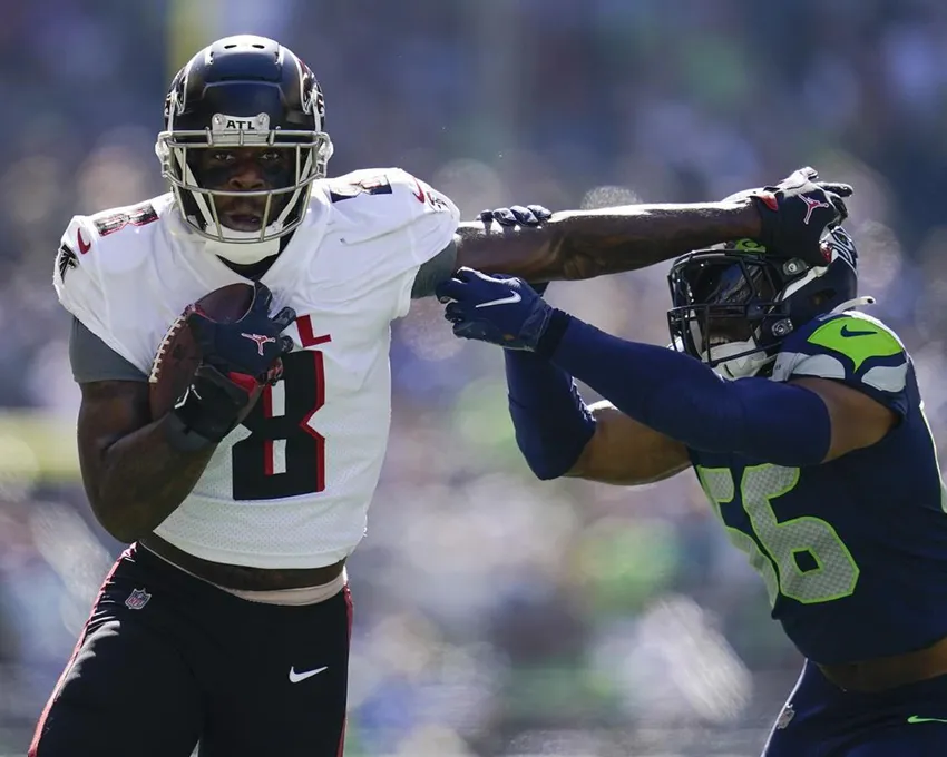 Le tight end Kyle Pitts des Atlanta Falcons s'éloigne du linebacker Jordyn Brooks des Seattle Seahawks pendant la première mi-temps d'un match de football NFL, dimanche 25 septembre 2022, à Seattle.
