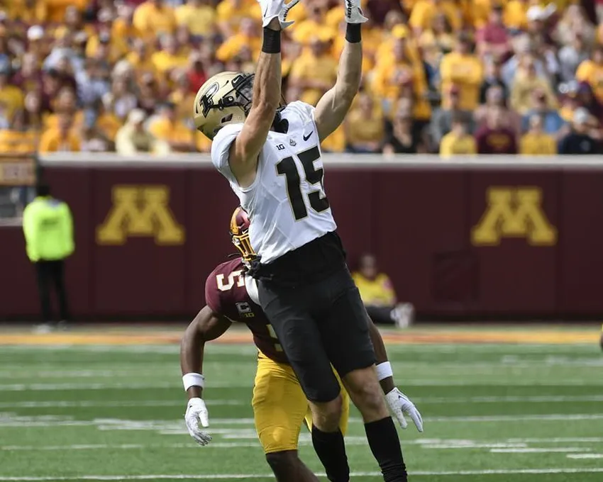 Le receveur large de Purdue, Charlie Jones (15), attrape une passe de 28 yards alors qu'il est défendu par le défenseur du Minnesota, Justin Walley (5), au cours de la deuxième mi-temps d'un match de football universitaire de la NCAA, samedi 1er octobre 2022, à Minneapolis. Purdue a gagné 20-10.