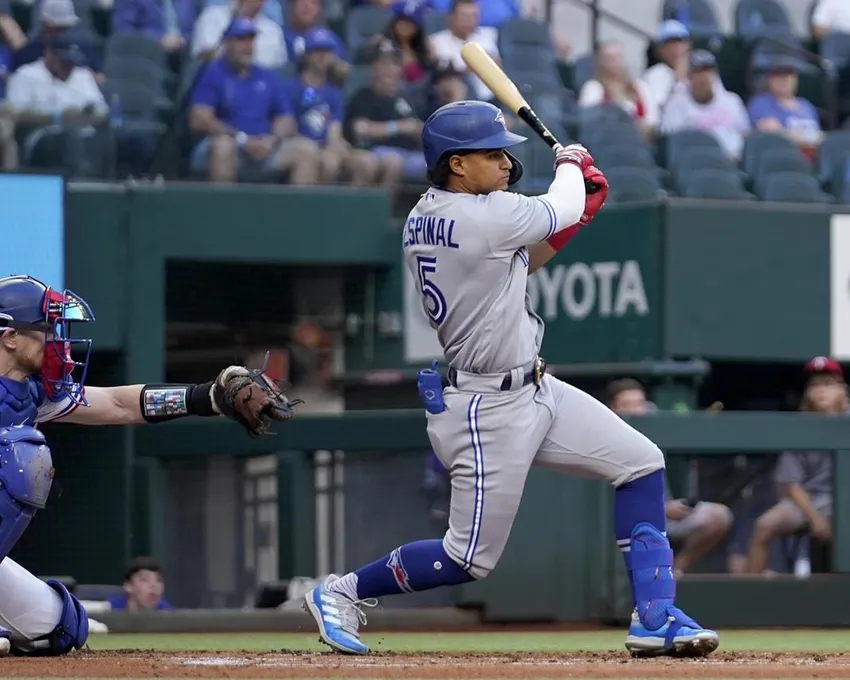 Santiago Espinal (5), des Blue Jays de Toronto, poursuit sa course avec un simple à deux reprises alors que le receveur des Rangers du Texas, Sam Huff, à gauche, observe la première manche d'un match de baseball à Arlington, au Texas, le samedi 10 septembre 2022.&nbsp;Espinal est de retour dans l'alignement des Blue Jays de Toronto pour le deuxième match de la série des cartes sauvages de la Ligue américaine.