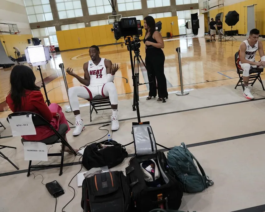 Bam Adebayo, deuxième à partir de la gauche, et Tyler Herro, en haut à droite, du Miami Heat, donnent des interviews à des journalistes de télévision lors de la journée des médias de l'équipe de basket-ball de la NBA à Miami, lundi 26 septembre 2022.