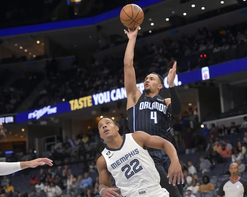 Jalen Suggs (4), garde du Magic d'Orlando, tire sur Desmond Bane (22), garde des Grizzlies de Memphis, lors de la première mi-temps d'un match de basket-ball de la NBA, lundi 3 octobre 2022, à Memphis, Tennessee.